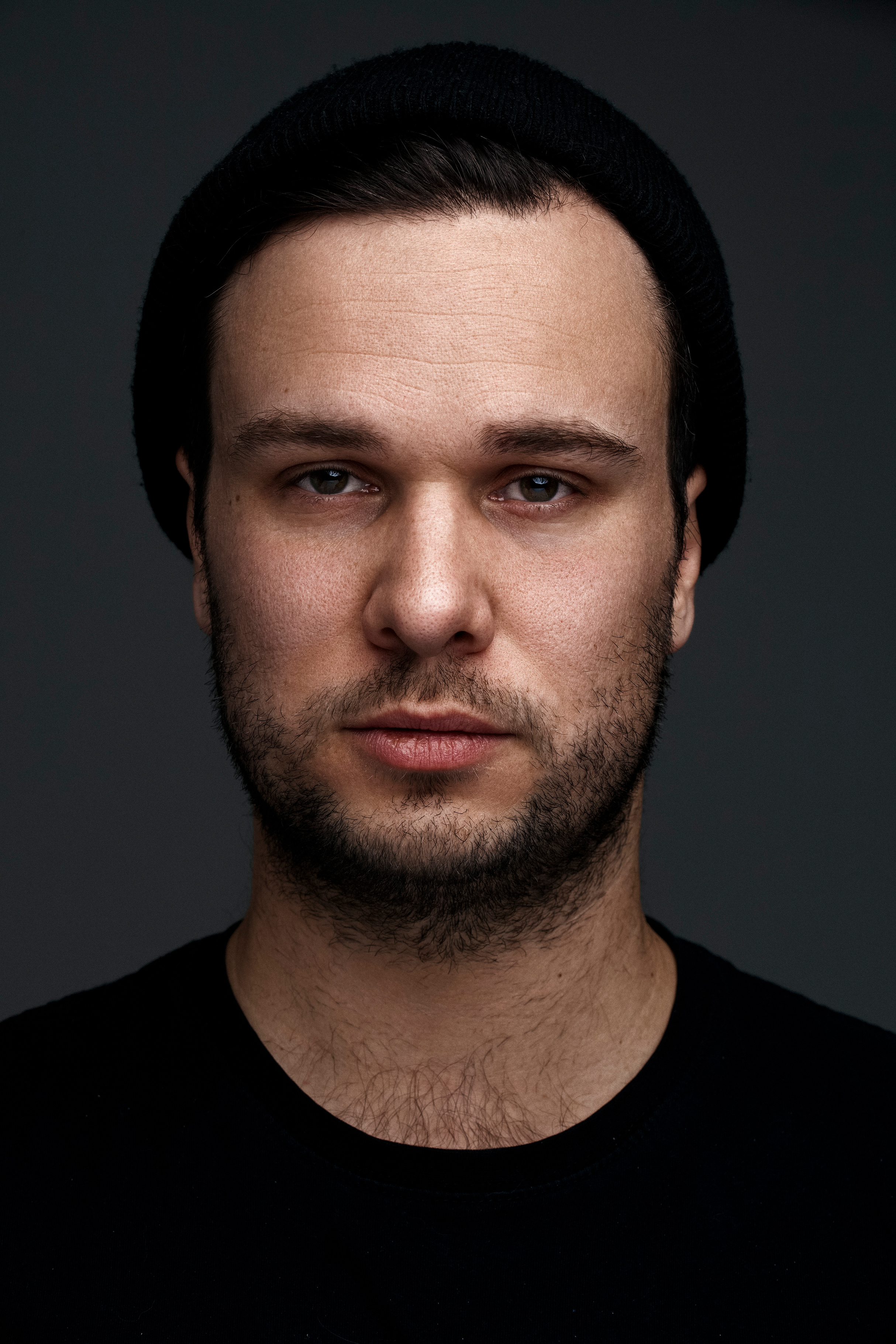 Portrait of artist for a print campaign imagined for tattoo MTL. Grey background, deep color skin tones.
